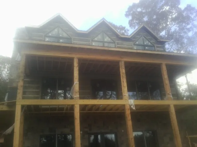Dormers and porch framing on a large log home under construction — Roof Coating work by our crew in Palisade